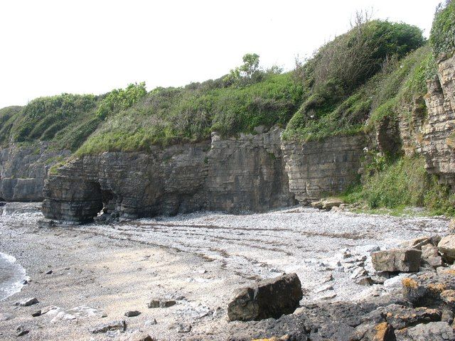 Shingle beach and natural arch at Huslan cove