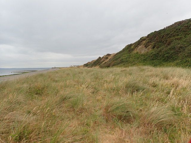 Rock armour protecting track on the edge of a raised beach from sea erosion